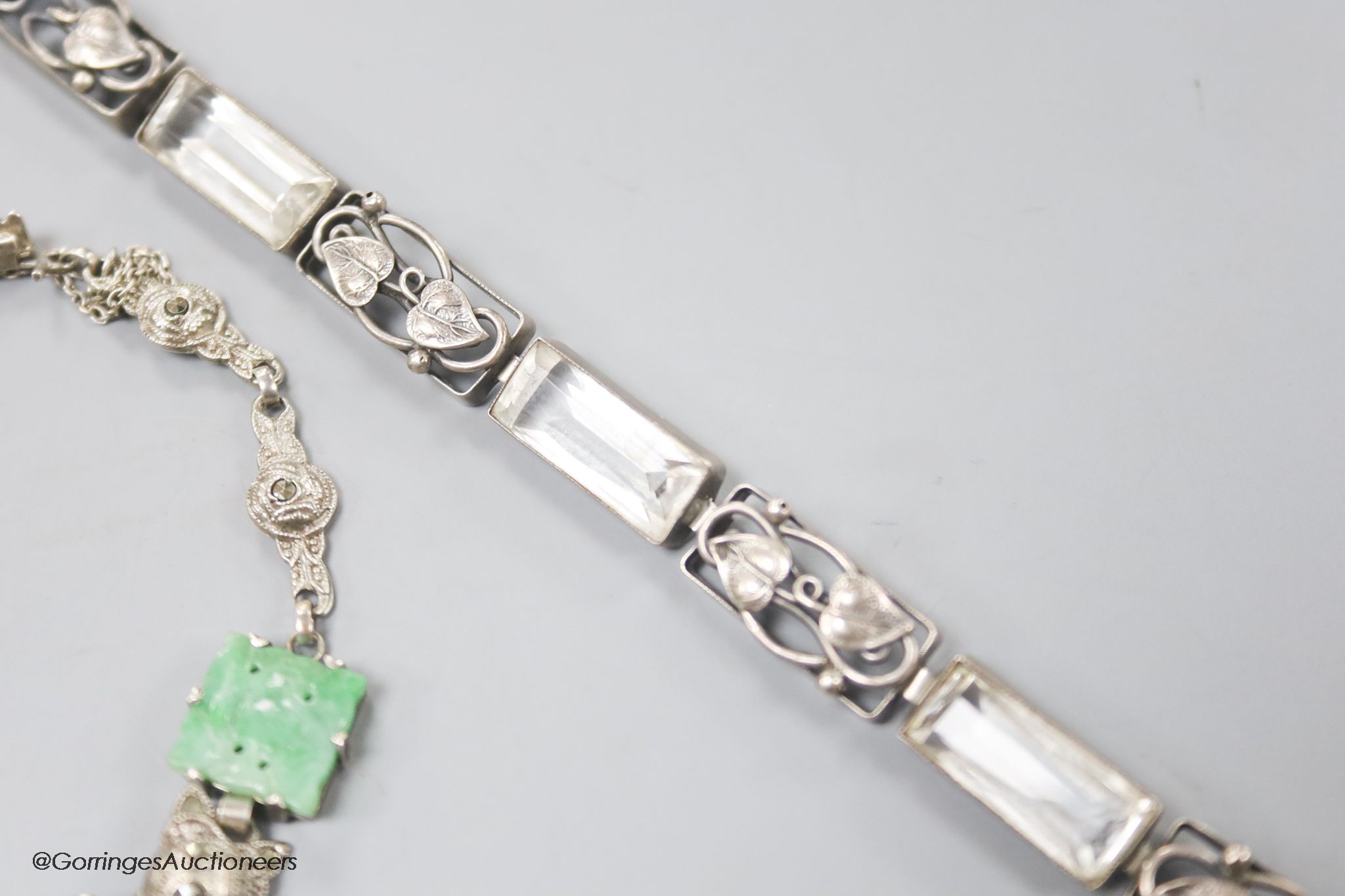 A white metal and carved jade set bracelet and one other bracelet.